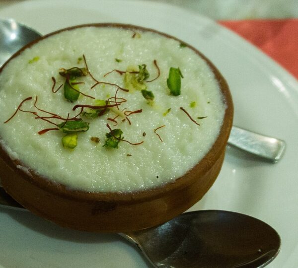 Kashmiri Phirni creamy rice pudding garnished with pistachios almonds and saffron