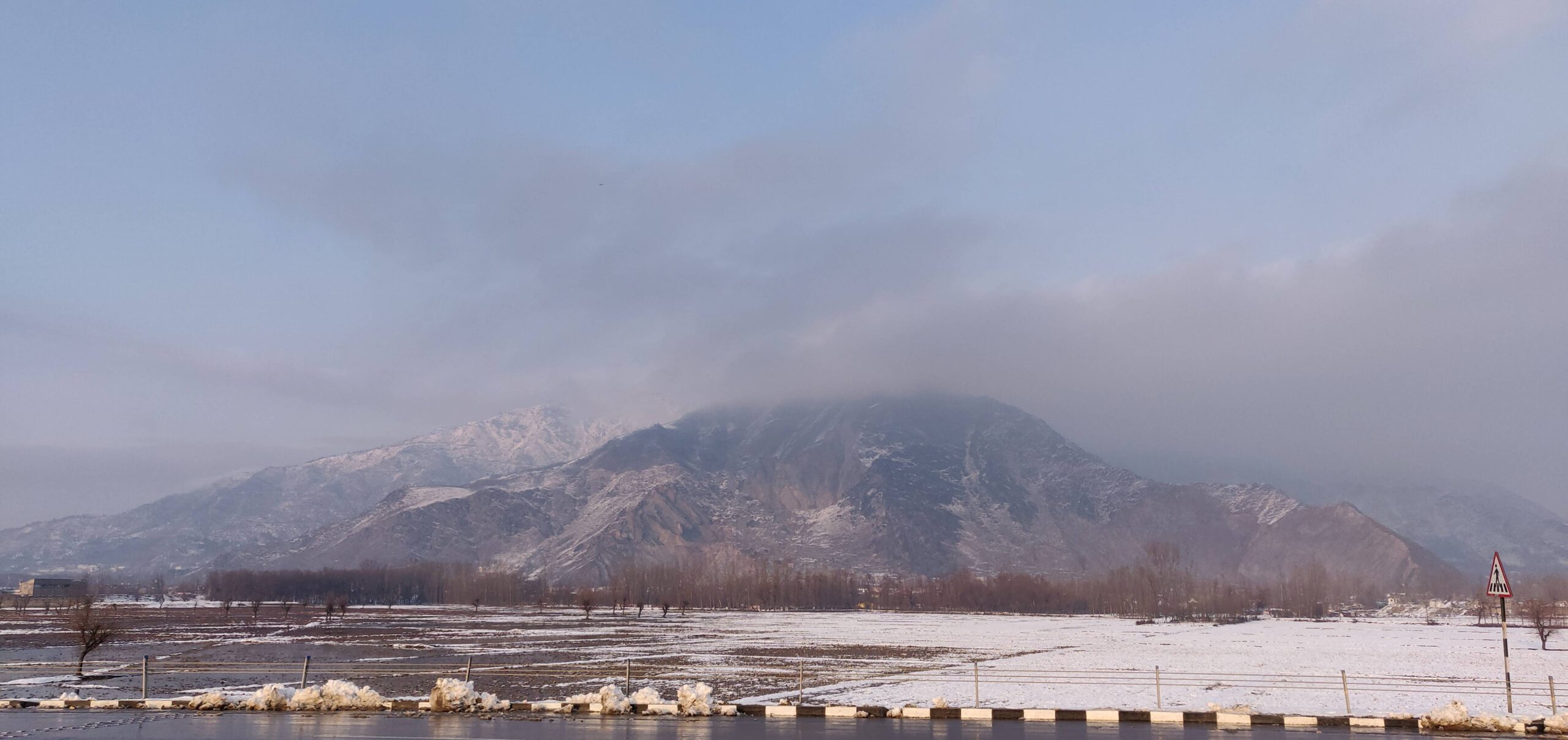 Kashmir landscape in winter with snow-capped mountains and frozen river — ideal backdrop for planning a 2026 Kashmir trip by season