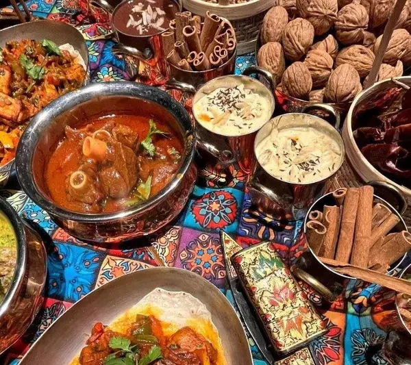 Traditional Kashmiri cuisine spread with Rogan Josh Yakhni and Kahwa tea representing warm hospitality