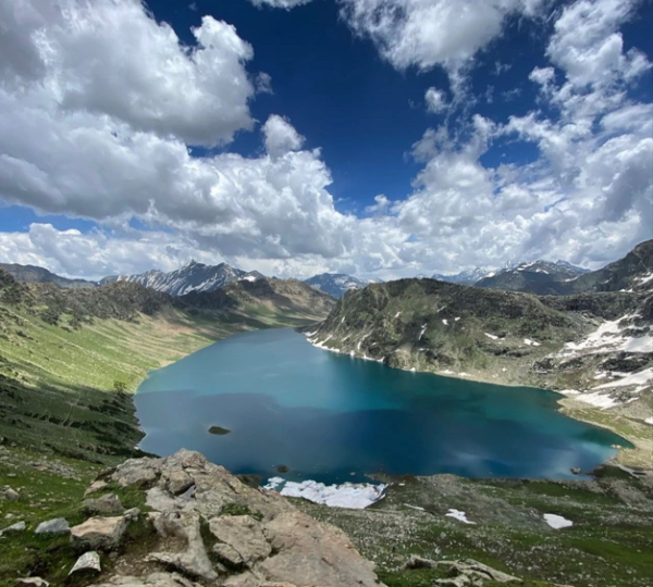 Tarsar Lake Kashmir — crystal clear glacial lake at high altitude perfectly reflecting the surrounding snow-capped Himalayan peaks, the centrepiece of the Tarsar Marsar Trek in Kashmir