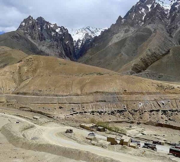 At 13478 feet highest point on Srinagar Leh National Highway with prayer flags and dramatic mountain landscape